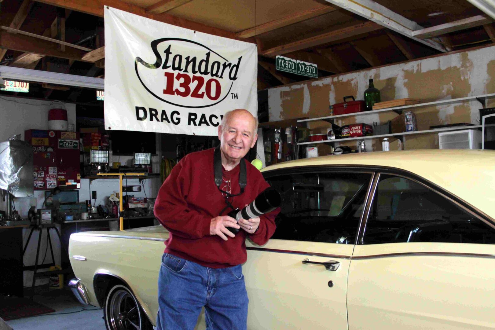 An old man with a DSLR camera in a garage