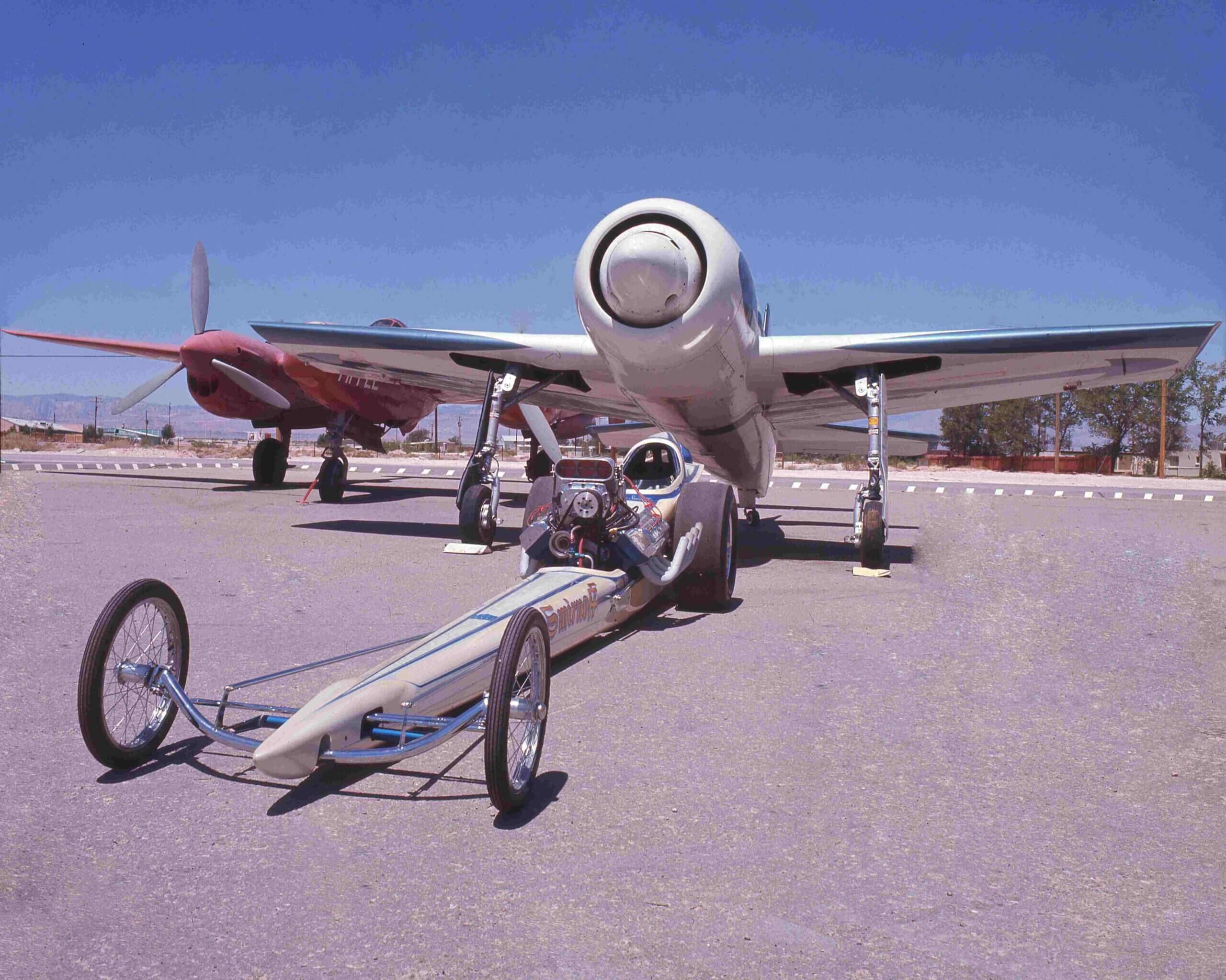 A vintage picture of a sports motor with an airplane